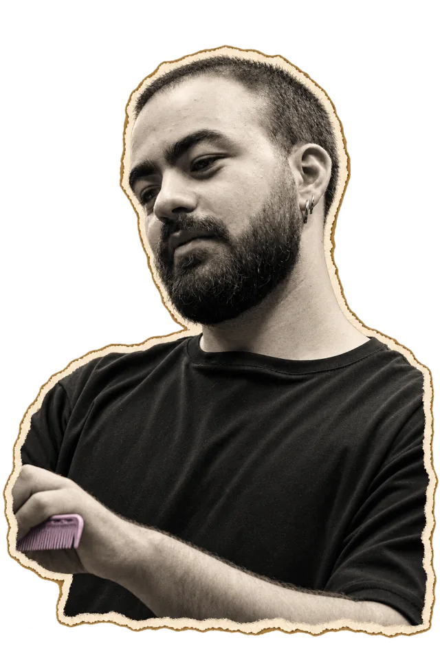 Dimitris with his arms crossed, holding a comb