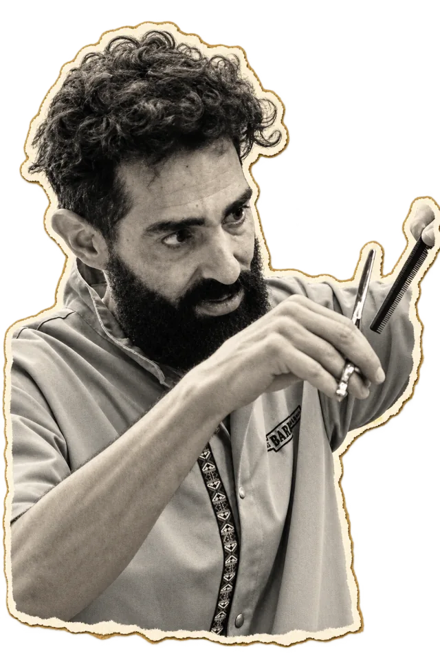 Giorgos with scissors and comb, in the middle of a haircut